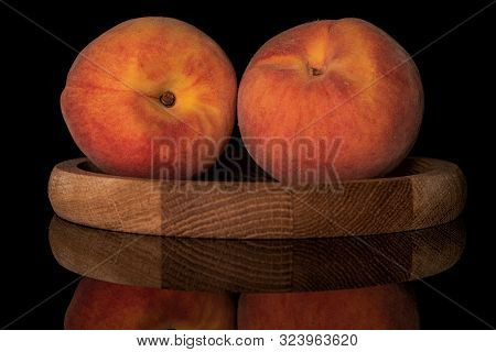 Group Of Two Whole Fresh Fuzzy Peach On Bamboo Plate Isolated On Black Glass