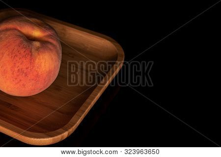 One Whole Fresh Fuzzy Peach Copyspace Right On Wooden Square Plate Isolated On Black Glass