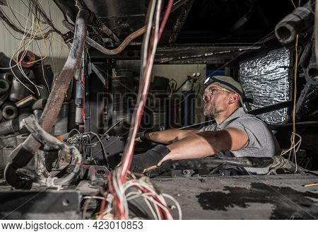 Caucasian Mechanic Inside Rv Coach Bus Diesel Engine Compartment. Replacing Whole Engine Of The Vehi