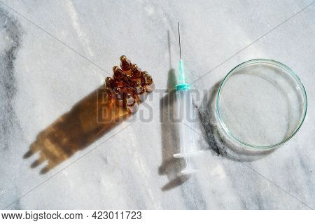 Glass Petri Dish With Transparent Pure Serum For Skin Care With Ampulas Ans Syringe On Marble White 