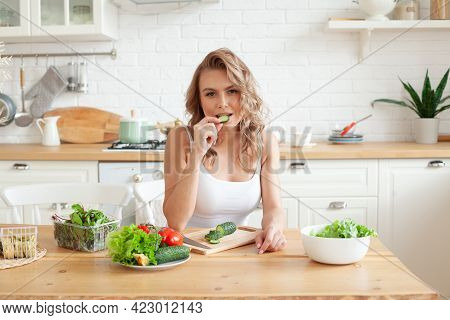 Beautiful Young Woman Is Preparing Vegetable Salad In The Kitchen. Healthy Food. Vegan Salad. Diet A