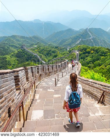 China travel adventure woman tourist backpacker walking backpacking on the Great Wall at famous Badaling destination in Beijing. Asia summer vacation tourism lifestyle. View of mountain landscape.