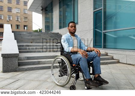 Portrait Of Unhappy Black Impaired Man In Wheelchair Next To Siatrs Without Ramp, Feeling Stressed, 