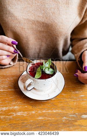 woman eating berry desset in cafe