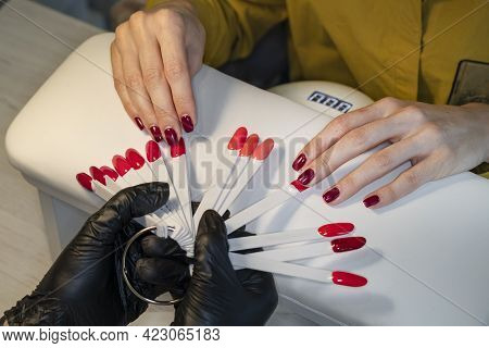 Gel Polish. Nail Polish In Different Colors. Woman At Nail Studio Chosing Color Of Nail Polish.