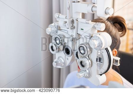 Selective Focus At Optometry Frame Equipment. While Doctor Using Penlight And Subjective Refraction 