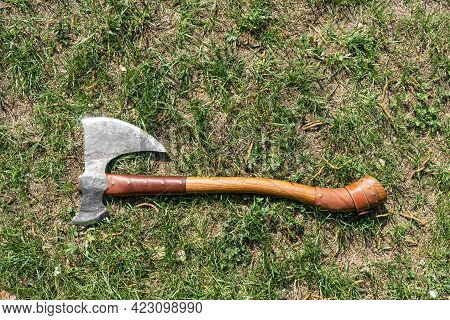The Battle Ax Is On The Ground Next To A Large Stone. Forged Ax