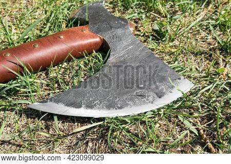 The Battle Ax Is On The Ground Next To A Large Stone. Forged Ax