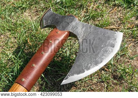The Battle Ax Is On The Ground Next To A Large Stone. Forged Ax