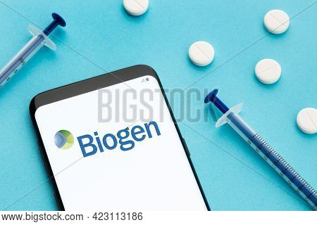 Galicia, Spain; June 8, 2020 : Smart Phone Showing Biogen Logo On Screen And Pills And Syringe On Bl