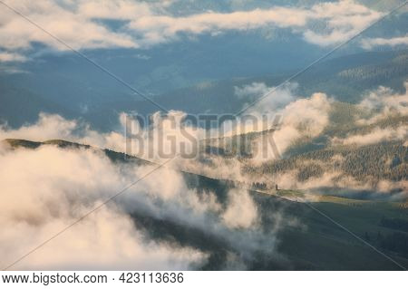 Low Clouds And Mountains Silhouettes. Picturecque Mountain Landscape After The Rain