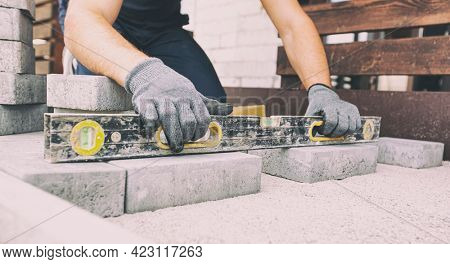 Worker lining paving slabs path