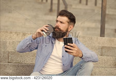 Drink It On The Go. Brutal Hipster Drink Coffee Sitting On Stairs. Bearded Man Enjoy Hot Drink Outdo