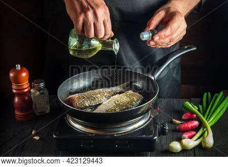 Professional Chef Prepares Fresh Fish In A Pan With Oil. Preparation For Cooking Fish Food. Working 