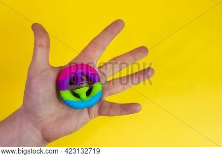 Trendy Anti-stress Toy Snappers In Mans Hand On Yellow Background With Copy Space.