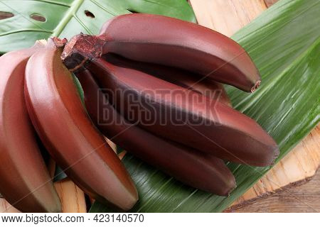 Delicious Red Baby Bananas On Wooden Table, Closeup View