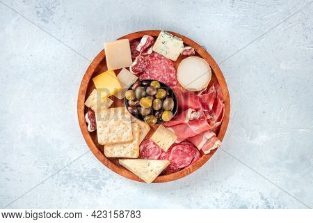 Charcuterie And Cheese Board, Shot From Above. Prosciutto Di Parma Ham, Blue Cheese, Olives And Crac