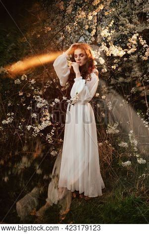 A Full-length Portrait Of A Romantic Girl, Looking Like A Forest Fairy, In A Blooming Garden With El