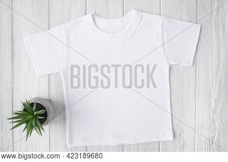 White Tshirt Mockup On Brown Wooden Background. Template, Flat Lay