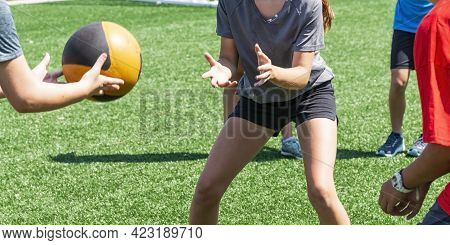 Young Boys And Girls Are Throwing And Catching A Medicine Ball At Practice During Summer Sports Camp