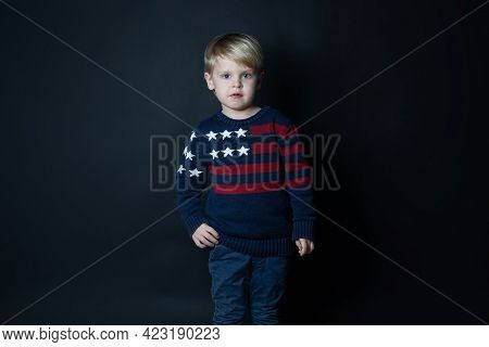 Cute Caucasian Boy In Sweater With Usa American Flag On Black Background With Copy Space.