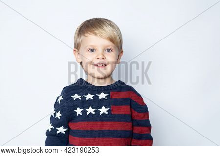 Surprised, Enthusiastic Child In A Sweater With An American Flag On A White Background.