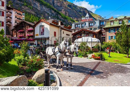 Zermatt, Switzerland - July 15, 2019: Horse Coach And Traditional Local Houses In The Centre Of Zerm