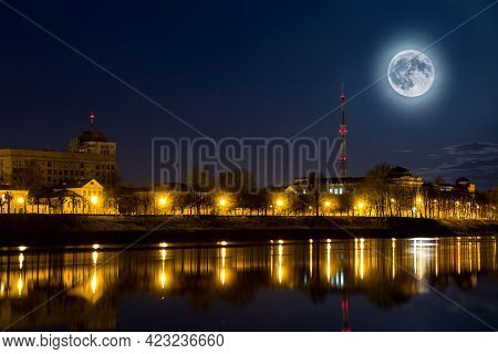 Full Moon Over The City. Night Landscape. Lantern Lights Are Reflected In The Water. Supermoon.