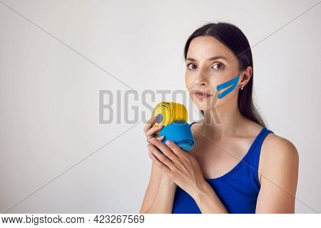 Woman Holds Two Skeins Of Kinesio Tape In Her Hand
