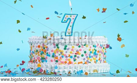 Colorful tasty birthday cake with candles shaped like the number 7.