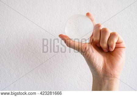 Close Up Of Someone Hand Holding A Clear Transparent Crystal Ball. The Use Of Crystal Balls To Predi