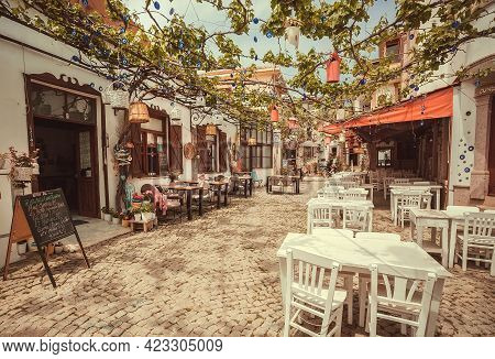Ayvalik, Turkey: Sunny Cafe With Terrace With Tables And Without People On Touristic Area Of Cunda I