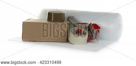 Bubble Wrap Roll, Cardboard Box And Tape Dispenser On White Background
