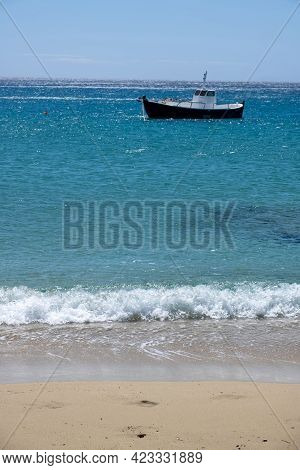 Greece, Cyclades. Traditional Boat Anchored On Blue Color Sea Water