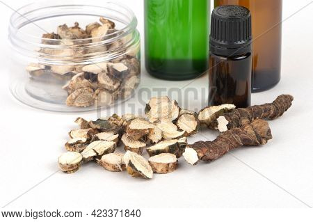 Dried Acorus Calamus Roots, Also Known As Sweet Flag, And Bottles With Oil And Extract Isolated On L