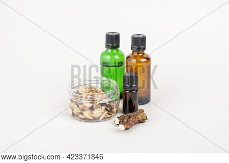 Dried Acorus Calamus Roots, Also Known As Sweet Flag, And Bottles With Oil And Extract Isolated On L
