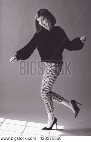 Woman in a fluffy sweater hopping with high heels