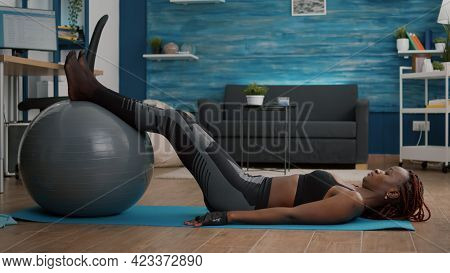 Slim Woman With Black Skin Doing Abs Exercise Using Fitball Flexing Abdominal Muscles During Yoga Yo