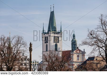 White Gothic Stone Bell Tower With Clock Near All Saints Church On Main Peace Square, Baroque Plague