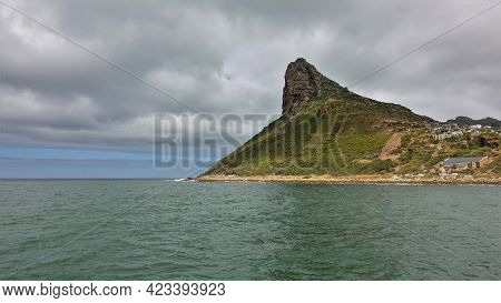 Cape In The Atlantic Ocean. A Picturesque Mountain With Bizarre Outlines And A Sharp Peak Against Th