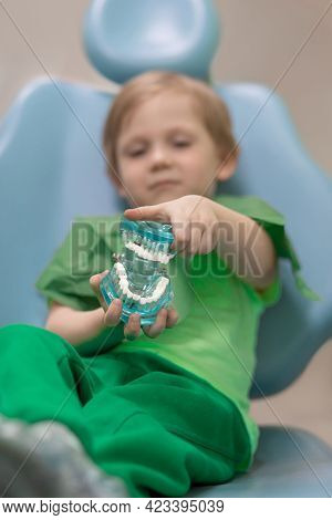 Selective Soft Focus. Kid Child Hands Hold Glass Jaw With Aching White Teeth With Caries And Pulpiti