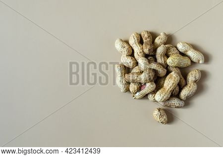 Inshell Peanuts And Scattered Inshell Peanuts On A Light Brown Background Top View. Walnut Peanut Ko