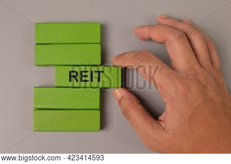 Hand Picked Wooden Block Written With Reit Stands For Real Estate Investment Trust.