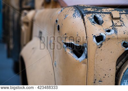 Bullet And Shrapnel Holes On The Front Of A Yellow Vehicle Painted In Desert Camo Colors. Concepts O