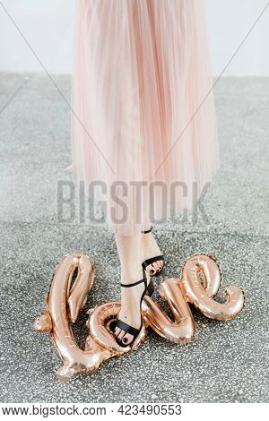 Woman stepping on a foil balloon on the ground