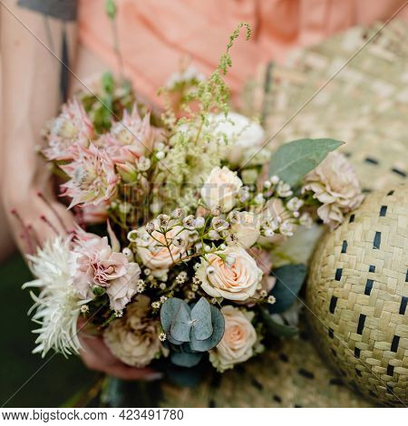 Woman in an orange jumpsuit with a bouquet of flowers
