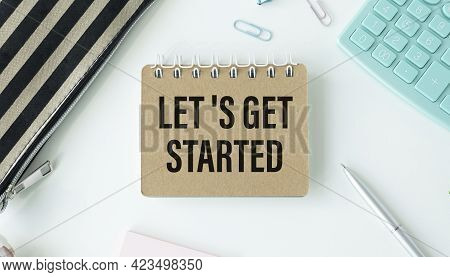Lets Get Started Writing On Tablet Screen With Laptop, Notebook And Coffee Lying On Wooden Office De