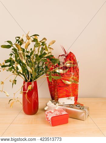 Luxury Packed Gifts In Red And Silver With Mistletoe In Vase
