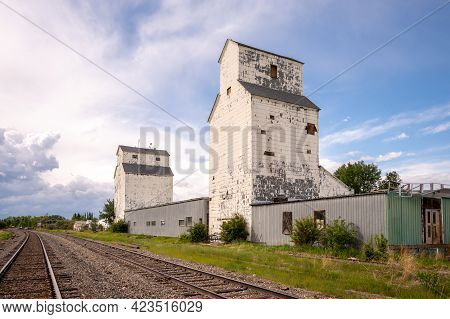 De Winton, Alberta - May 5, 2021: Old Grain Elevators Outside The Small Town Of De Winton, Alberta.