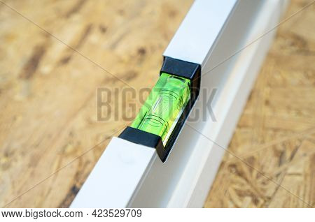 Water Level Tool Lying On The Osb Sheet. Spirit Level Bubble Shows The Ideal Parameter.